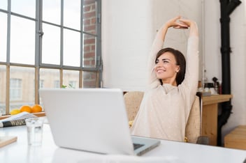 woman at her laptop sitting beside her kitchen window