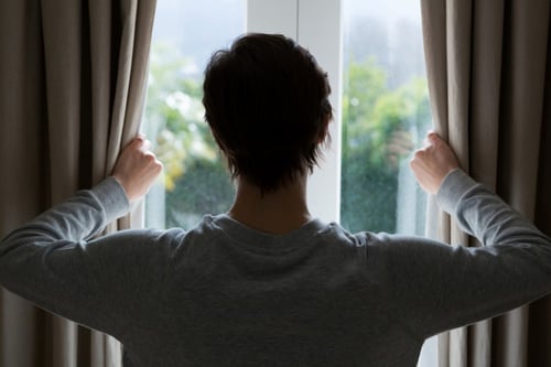 woman looking through window at home 2021 08 28 18 10 06 utc