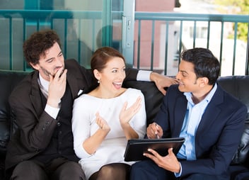 Couple and financial consultant sitting on a couch and discussing home improvement financing