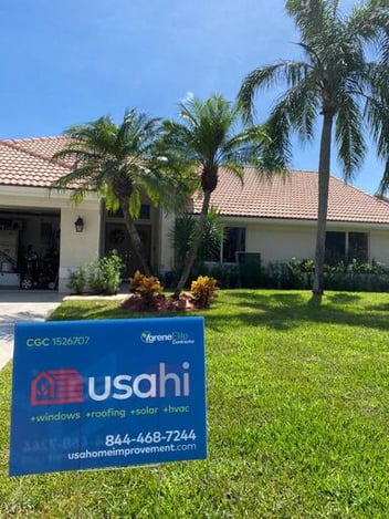 South Florida home with a USA Home Improvement sign on the front lawn