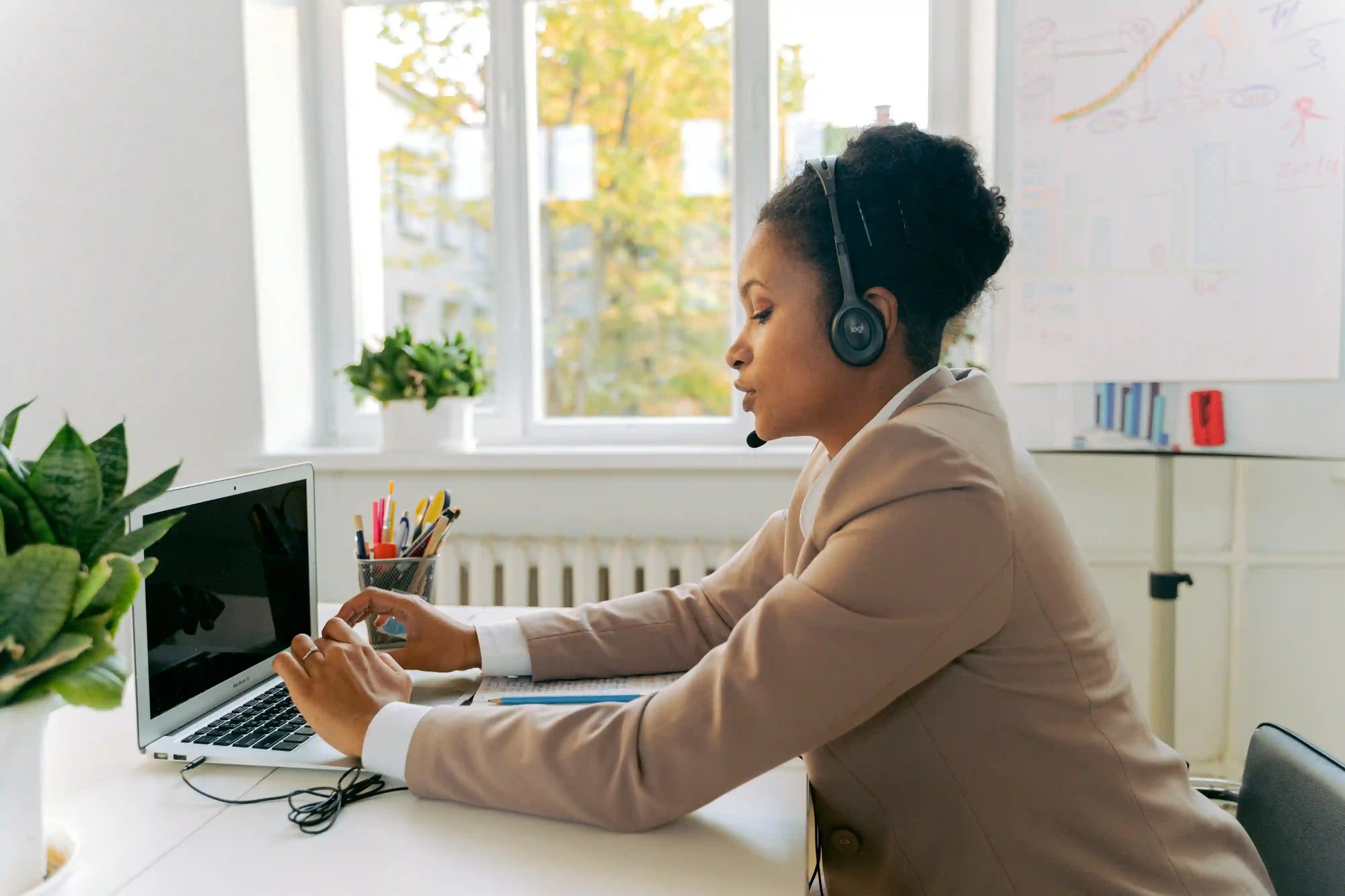 woman sat at desk with a bluetooth headset