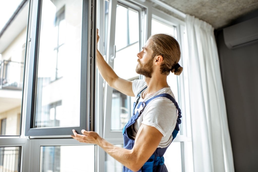 workman-adjusting-window-frames-at-home-2021-10-13-18-32-06-utc